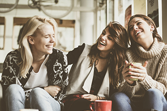 três mulheres sentadas alegremente graças aos serviços da Chevrolet Serviços Financeiros